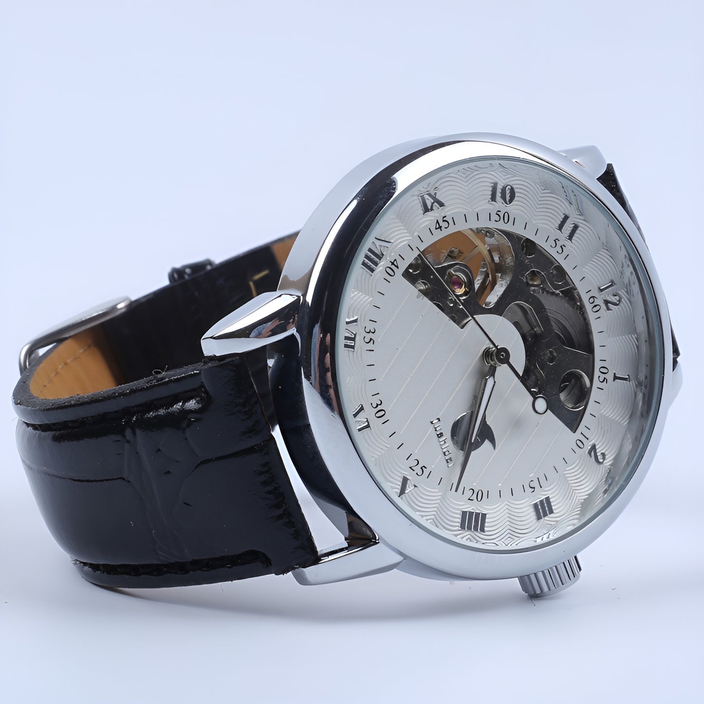 Mechanical watch with black strap and silver case on a light blue background