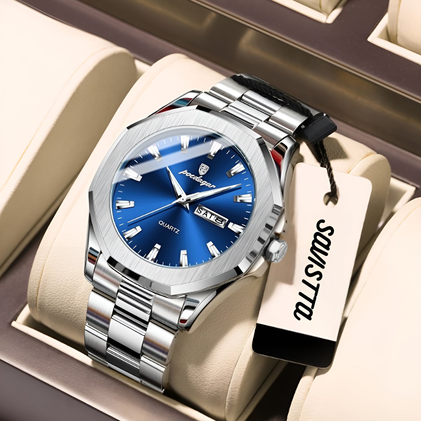Silver watch with blue dial in a display case, featuring the brand 'Poedagar'.