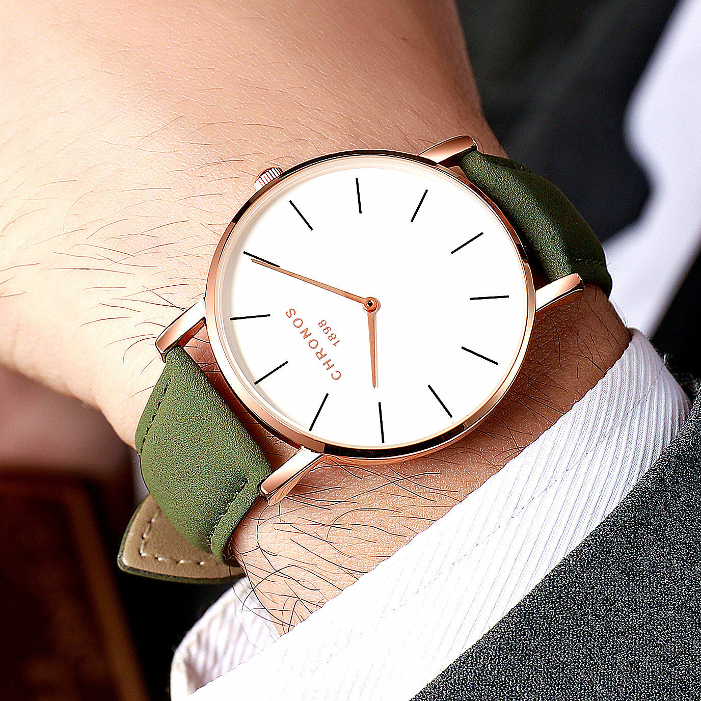 Wristwatch with green strap and rose gold case on a wrist