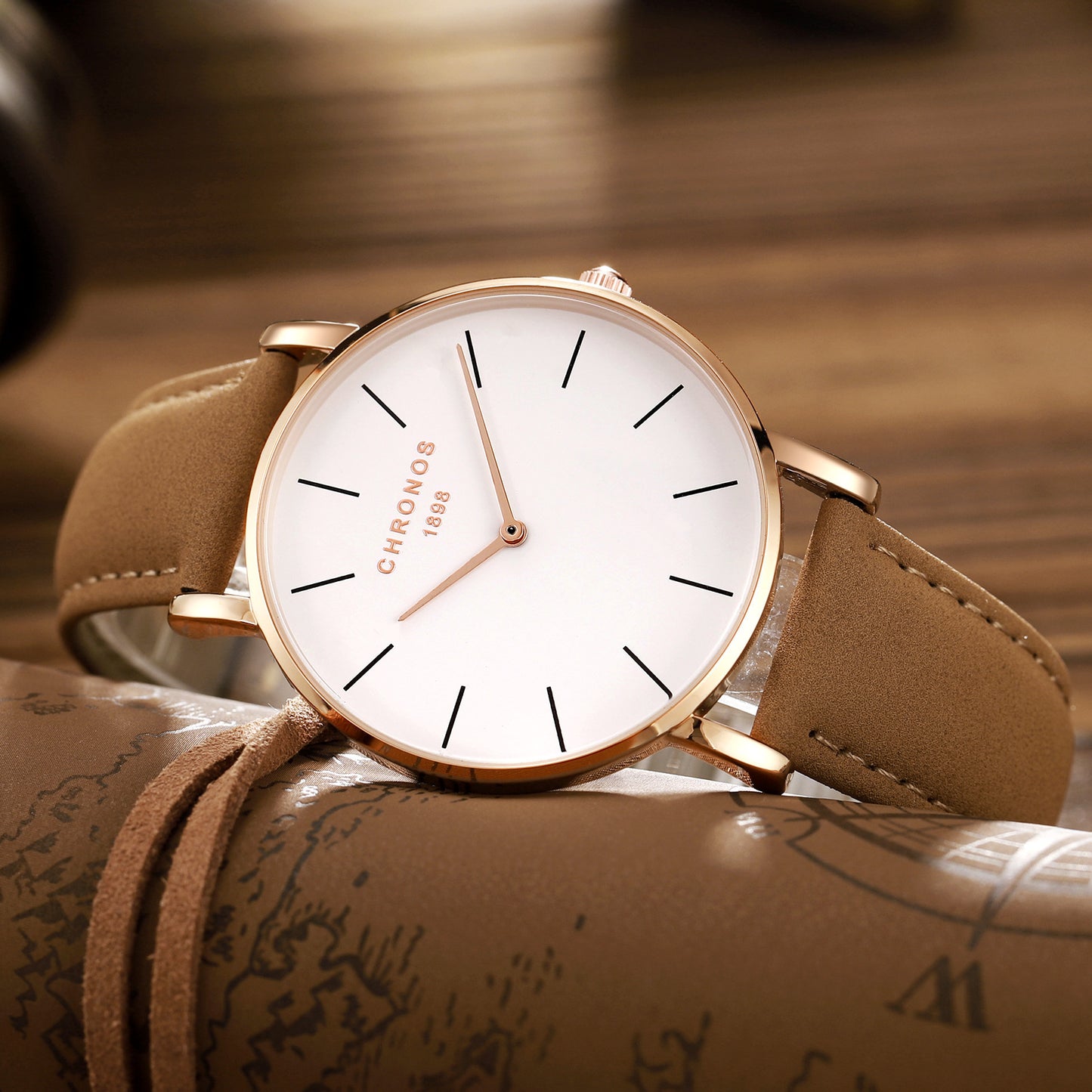 Watch with brown strap and white face on a textured surface