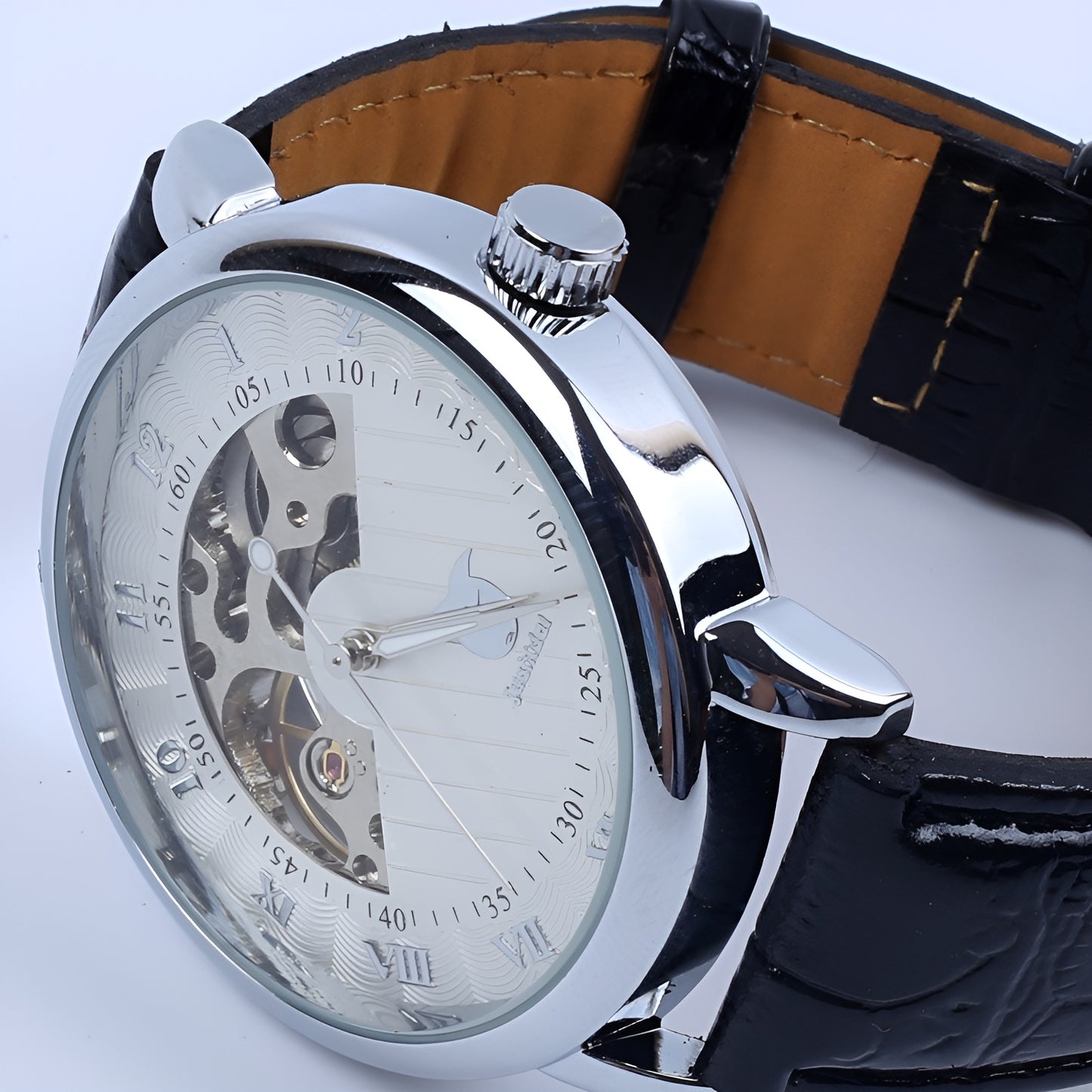 Close-up of a silver wristwatch with a black leather strap on a white background