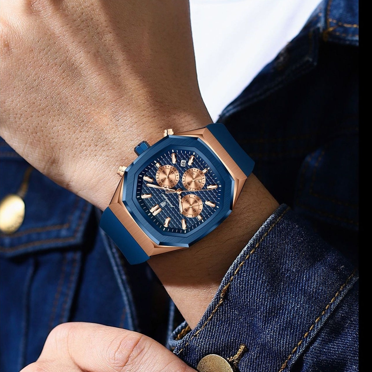 Blue and rose gold watch on a person's wrist with denim background