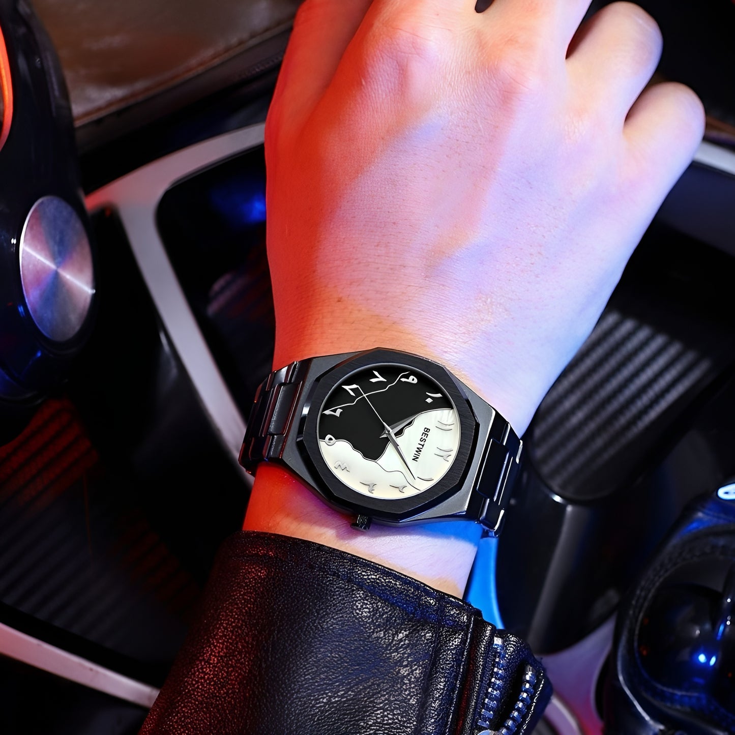 Hand wearing a black wristwatch with a detailed face in a car interior.