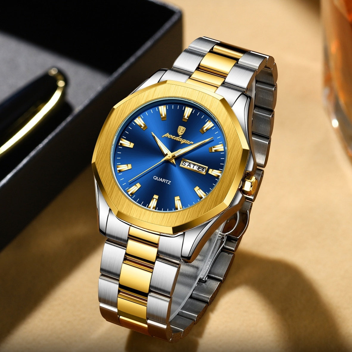 Luxury watch with blue face and gold and silver band on a beige surface